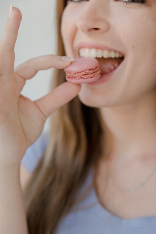 Free A Woman Eating Pink Macaron Stock Photo
