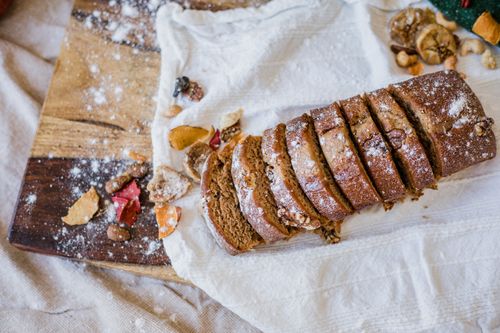 Free Delicious homemade brown bread sliced on a rustic wooden board with nuts and flour. Stock Photo
