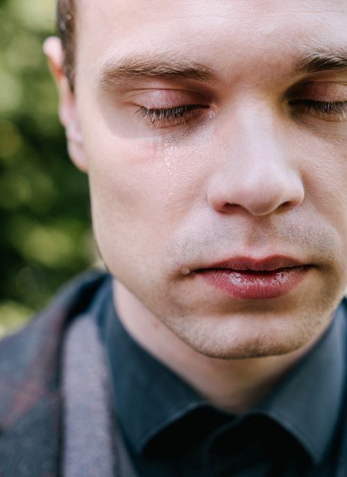 Free Close-up portrait of a man with tear on cheek depicting sadness and grief. Stock Photo