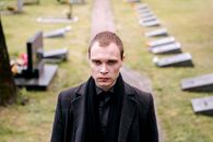 Man in Black Suit Jacket Walking in Cemetery