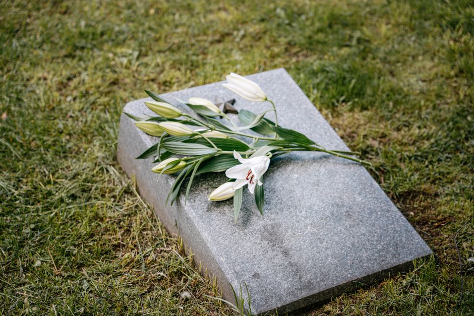 Dalle funéraire plate ornée de fleurs blanches dans l’herbe