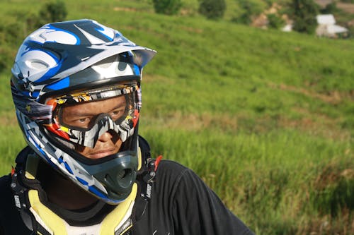 Man Wearing White Blue and Black Motorcycle Helmet during Daytime