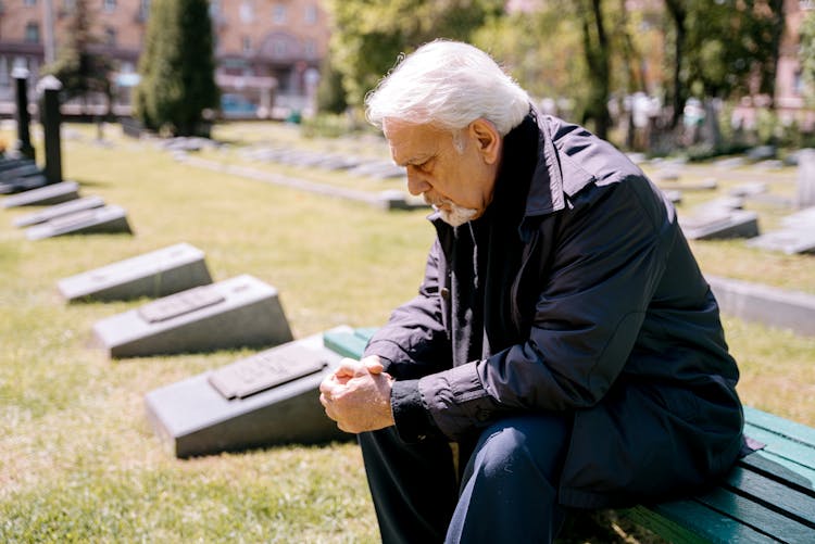 A Sad Elderly Man Sitting On A Bench