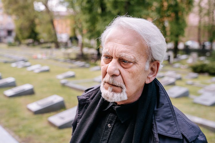 An Elderly Man In Black Jacket With A Sad Face