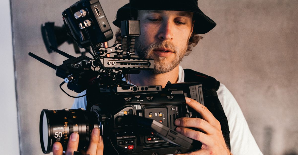 Pule Using His Camera A Man in a White Shirt and a Bucket Hat Using His Camera · Free Stock Photo