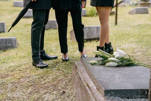 Free Three People Wearing Black Shoes Standing Near a Grave Stock Photo