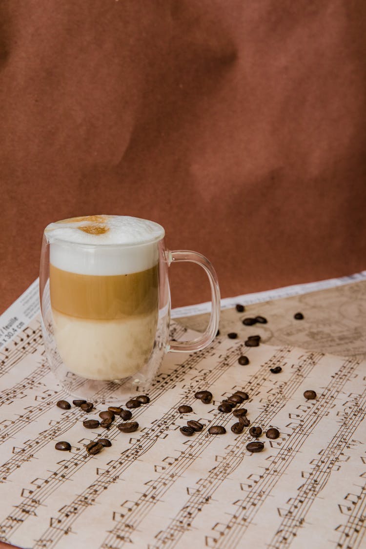 A Foamy Latte In A Glass Cup On A Music Sheet