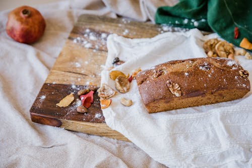 A Loaf of Walnut Bread on a Wooden Chopping Board