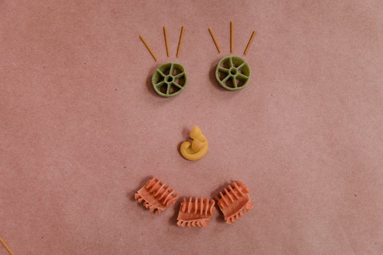 A Happy Face Made Out Of Various Pasta Noodles