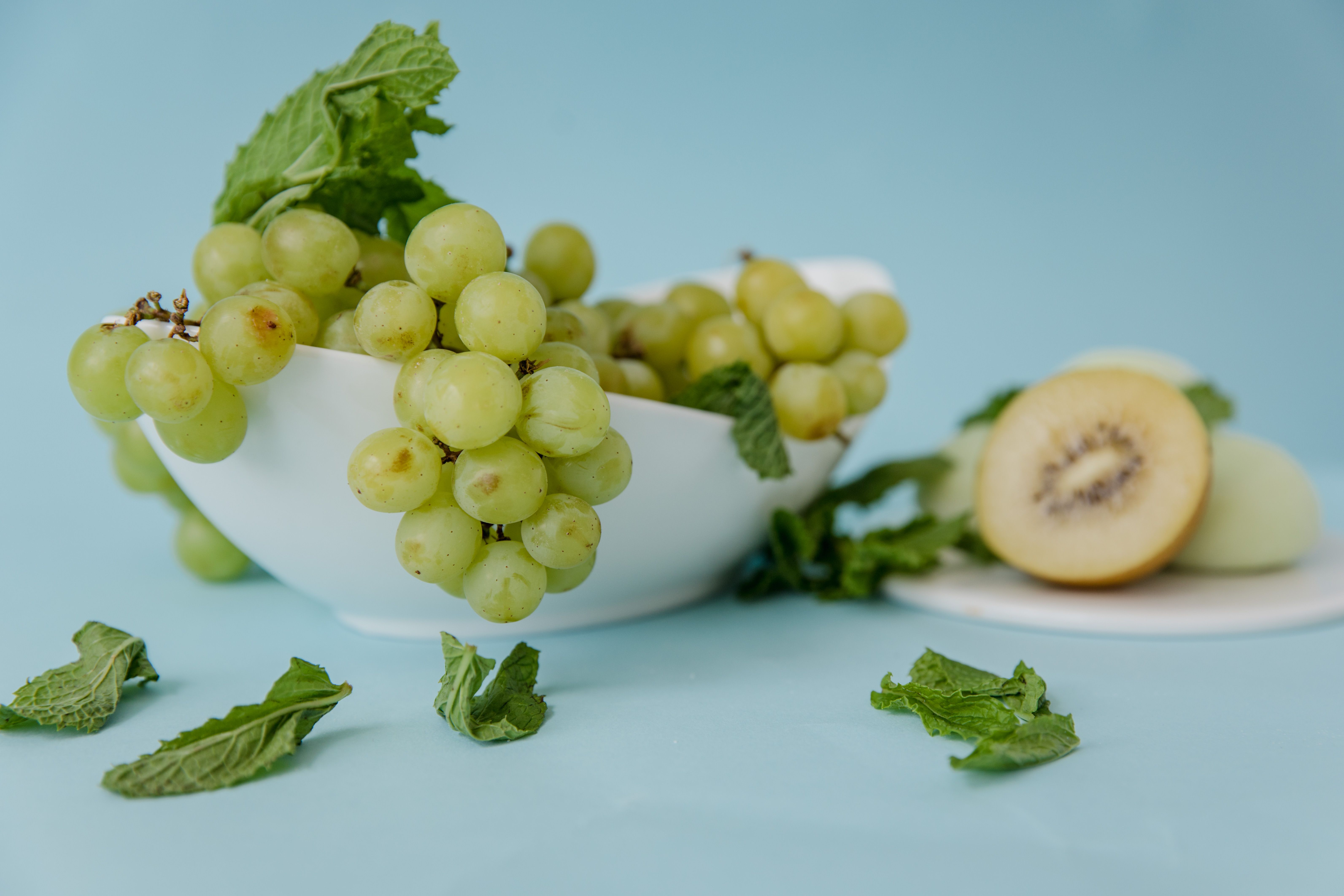 a close up shot of green grapes on a bowl