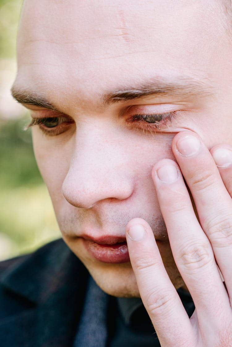 A Close-Up Shot Of A Man Wiping His Tears