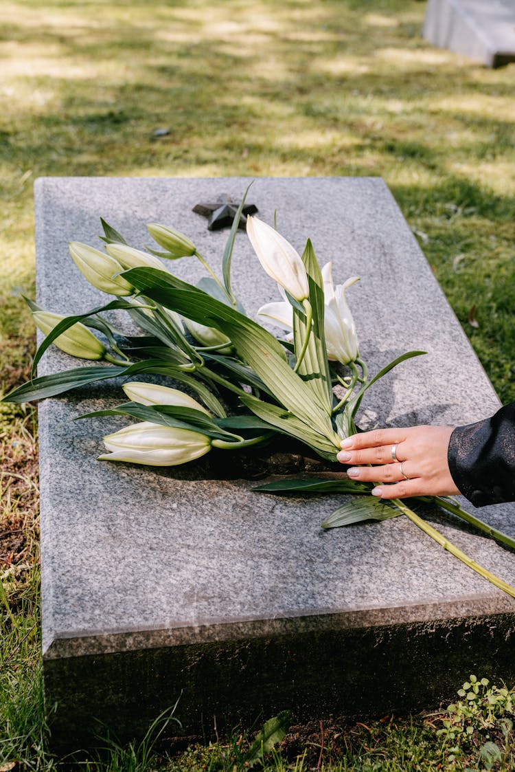 Laying Flowers Over A Tombstone