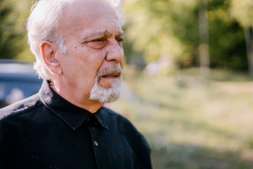 Free Elderly man with white hair and facial hair looks pensive outdoors. Bright day setting. Stock Photo