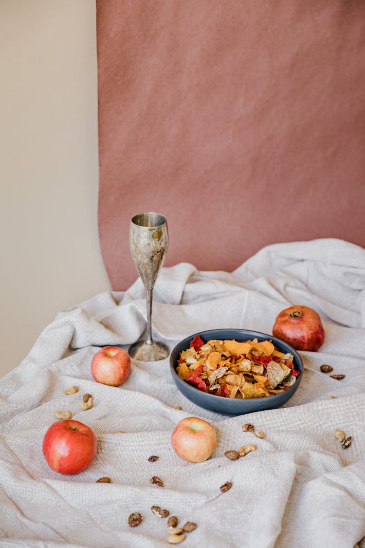 Food In A Blue Bowl Near Fresh Apples On A White Cloth