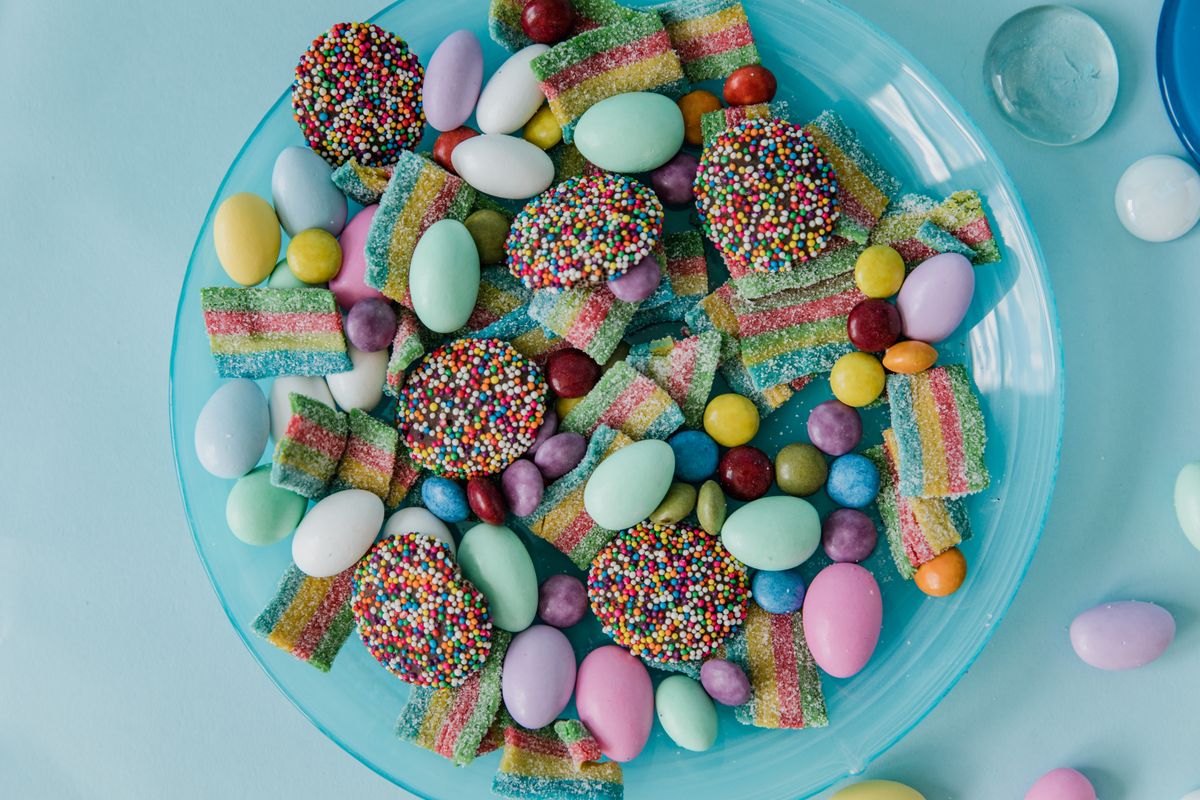 Top view of assorted colorful candies on a blue plate, ideal for sweet shops.