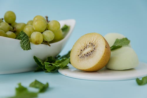 Free Sliced Kiwi Fruit beside a Bowl of Grapes  Stock Photo