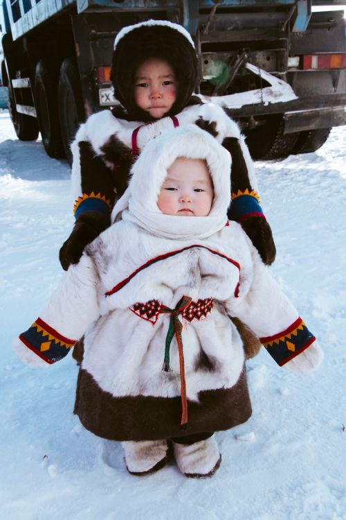Free Two children in traditional winter clothing, enjoying the snowy outdoors. Stock Photo