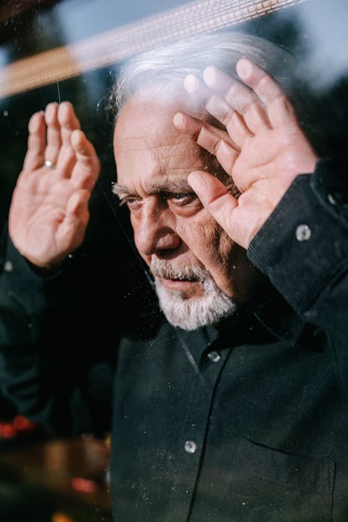 Elderly Man in Black Button Up Shirt Leaning on the Window