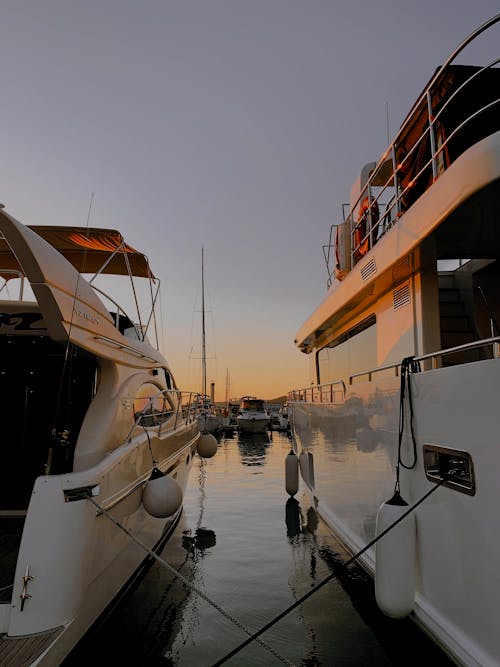 Two White Yachts on Water During Sunset