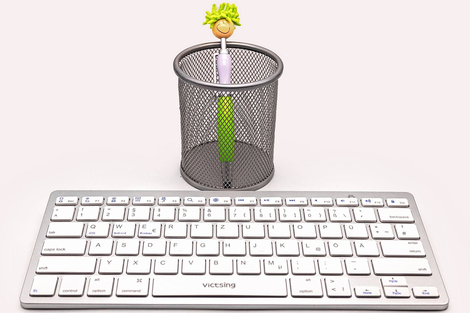 Minimalist desk setup featuring wireless keyboard and pen holder, ideal for modern office environments.