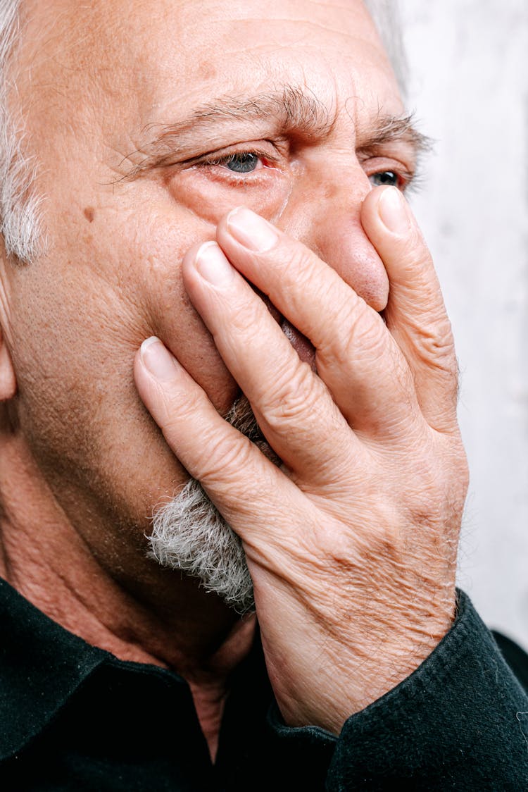 Man In Black Shirt Covering His Face With Palm