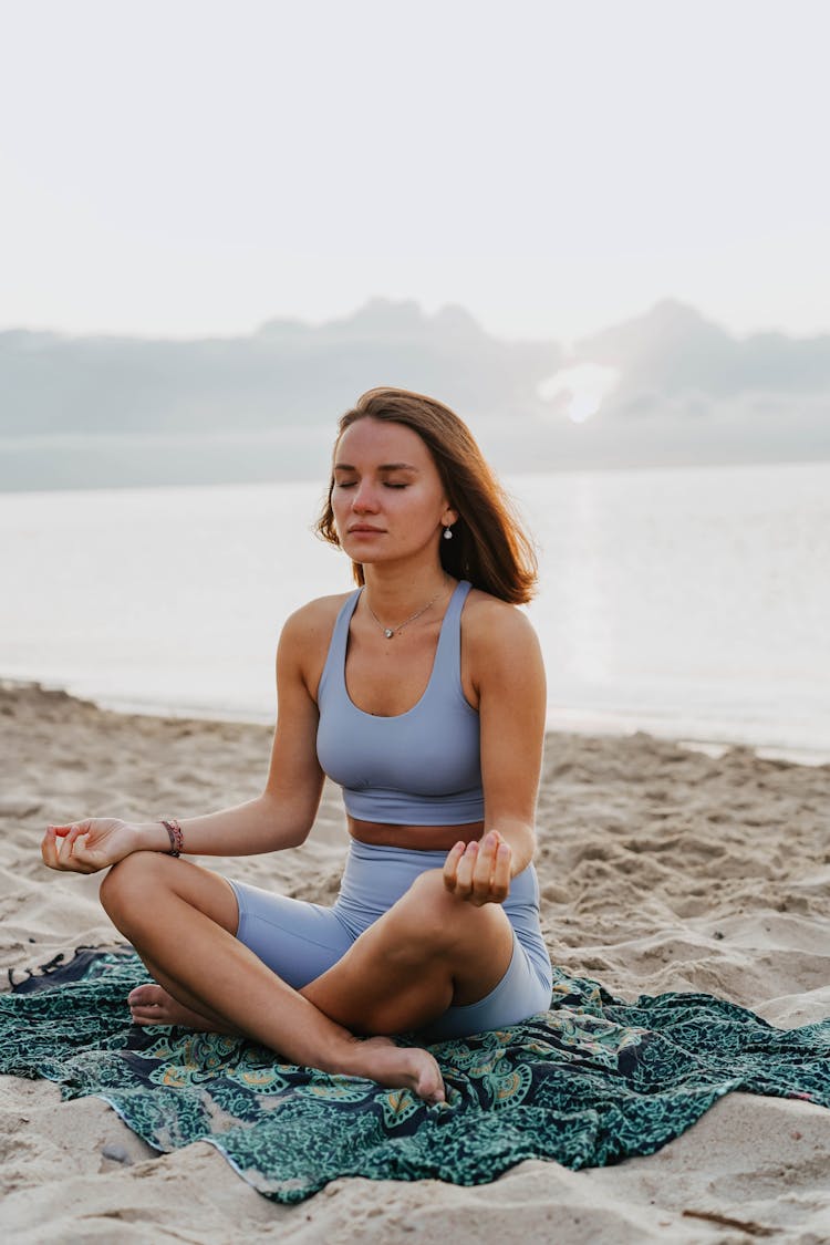 A Woman Doing A Meditation On A Beach During Morning