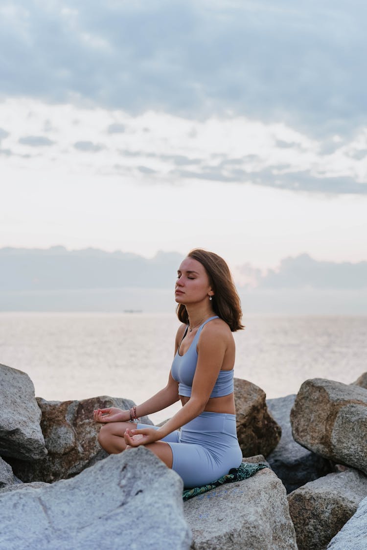 A Woman Doing A Meditation Near The Ocean During Morning