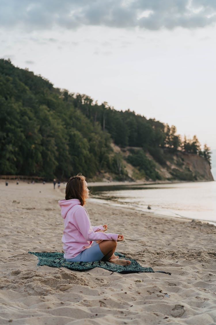 A Woman Doing A Meditation On A Beach During Morning