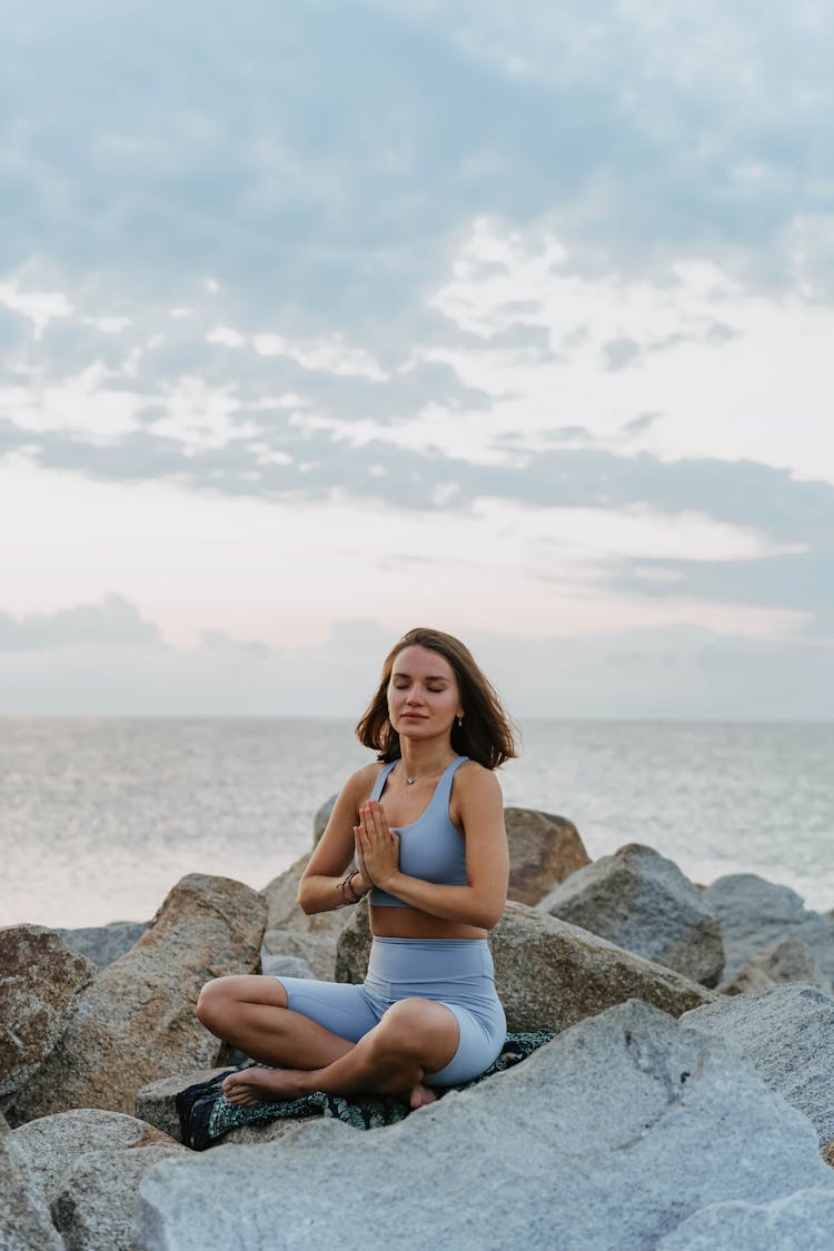 A Woman Doing A Meditation Near The Ocean During Morning