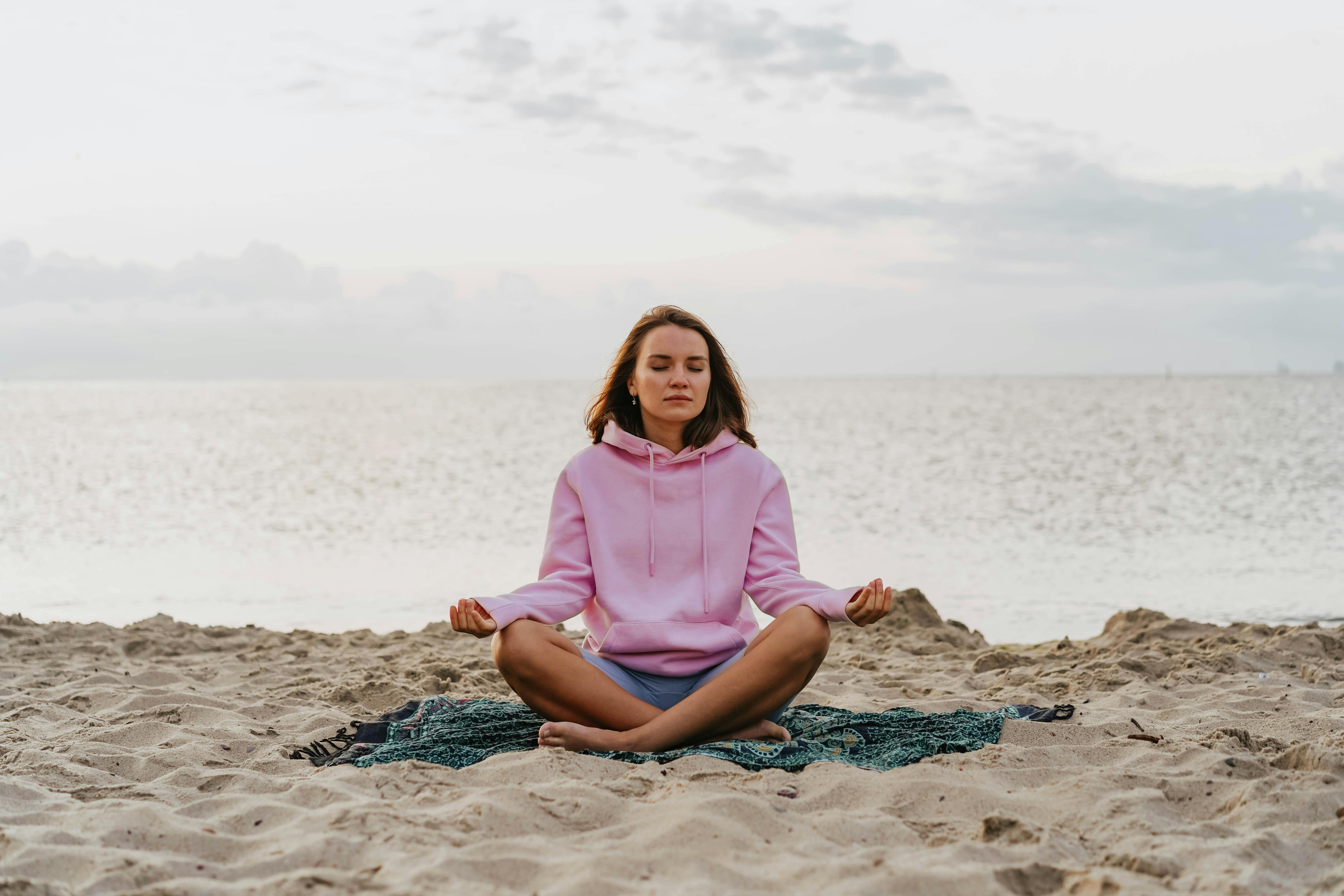 Woman meditating on a beach at sunrise — recovery from treatment-resistant depression is possible