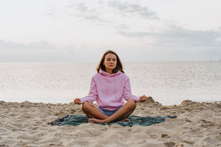 A Woman Doing A Meditation On A Beach During Morning