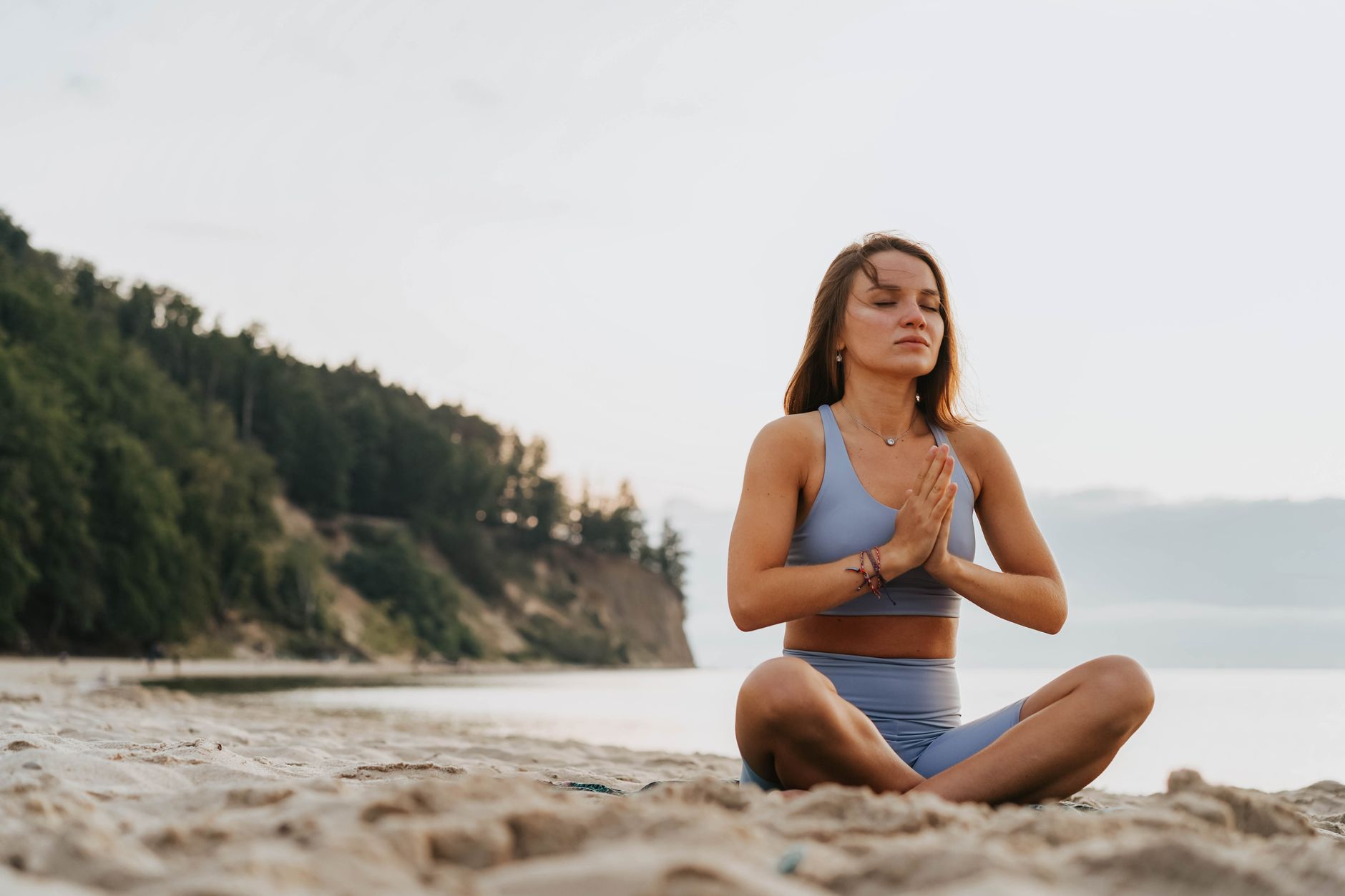 A woman meditating at sunrise, preparing for the day ahead.
