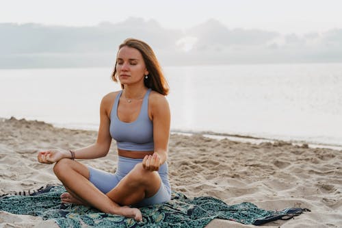A Woman Doing a Meditation on a Beach during Morning
