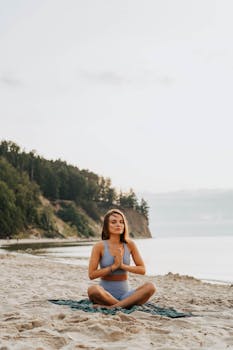 A woman meditating on the beach, practicing yoga for relaxation.