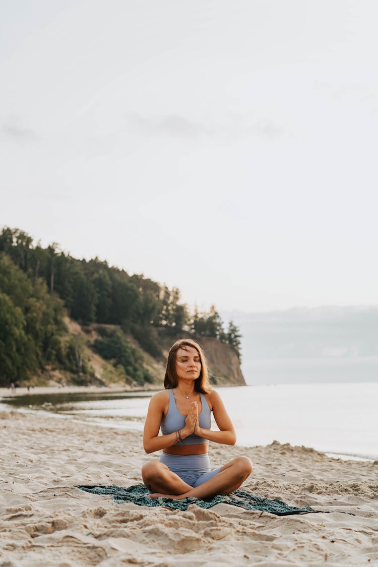 A Woman Doing A Meditation On A Beach During Morning