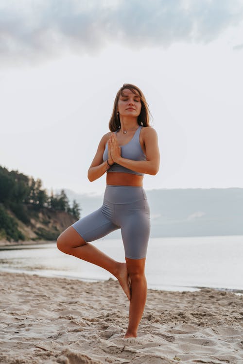 Free A Woman Doing a Yoga Exercise on a Beach during Morning Stock Photo