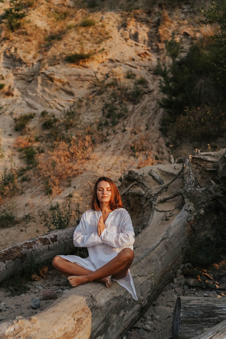 Woman In White Long Sleeve Dress Sitting On Driftwood