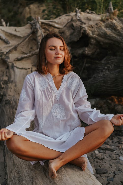 A Woman in White Dress Sitting while Meditating
