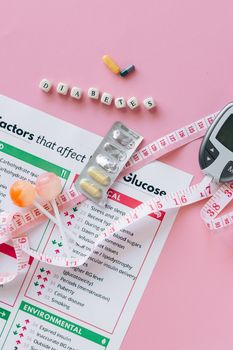 Flat lay of diabetes management essentials including glucose meter, pills, and informative leaflet.