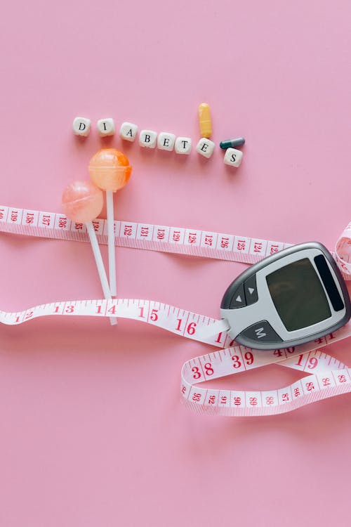 Close-Up Shot of a Glucometer beside a Tape Measure