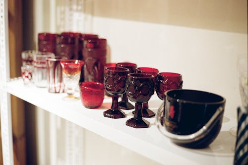 Red Glasses on White Wooden Shelf