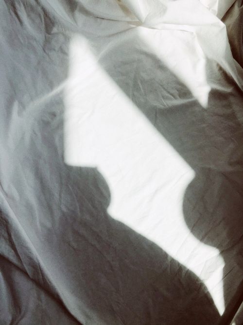 Free Creative play of light and shadow on a textured white linen surface. Stock Photo