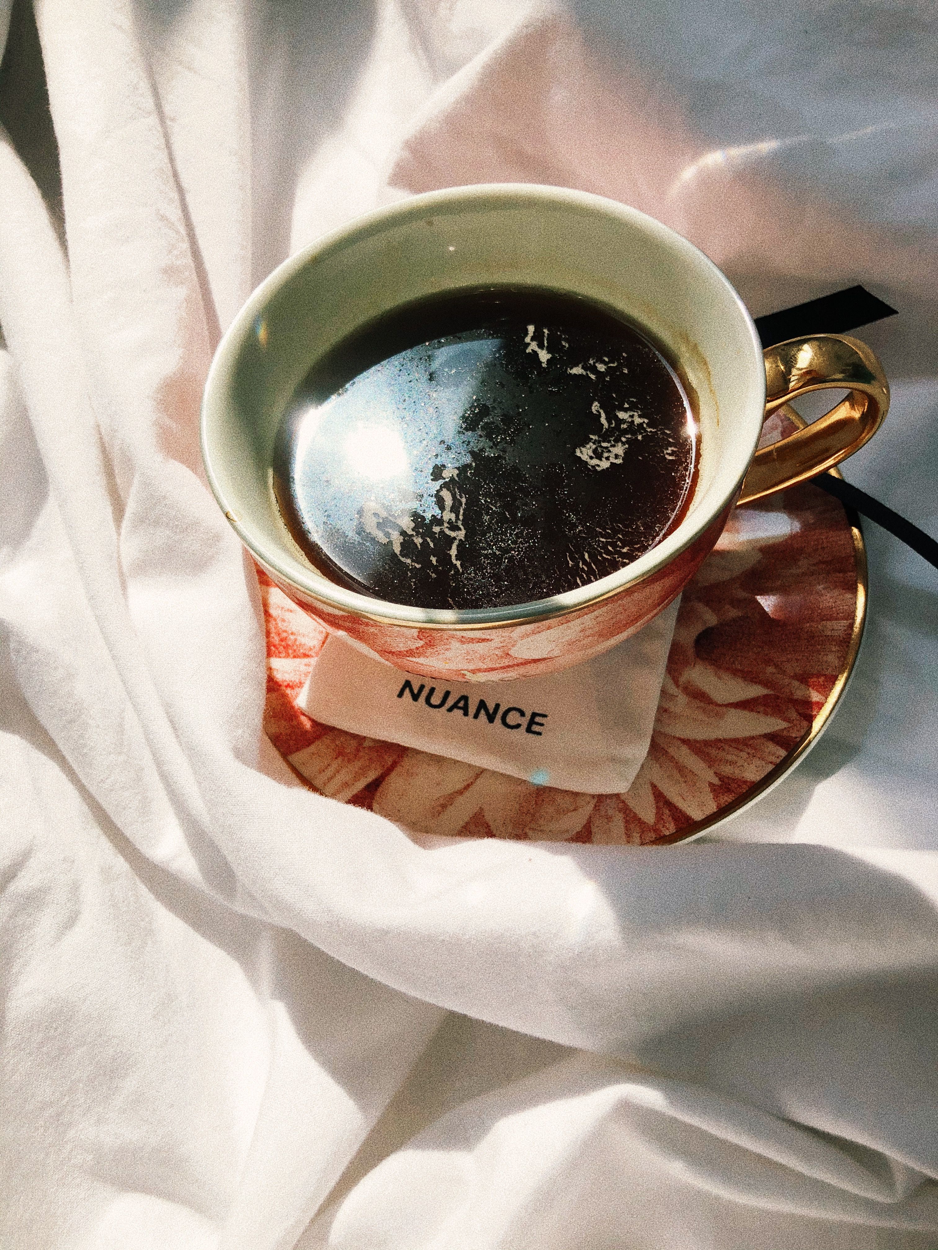 A beautifully styled coffee cup with a gold handle resting on a floral saucer. Perfect for cozy moments.