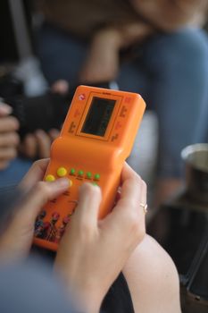 Person playing a classic handheld brick game, focusing on the retro gaming device.