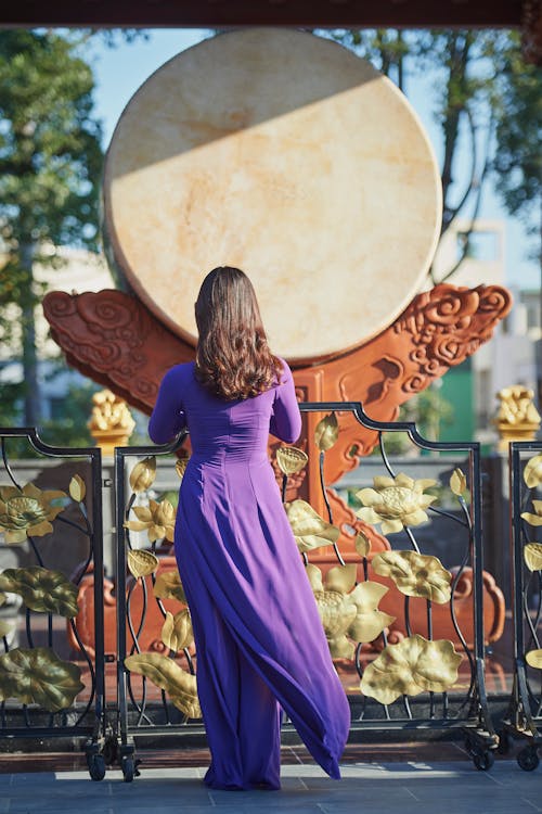 Darmowe zdjęcie z galerii z fioletowa sukienka, kobieta, metalowy płot