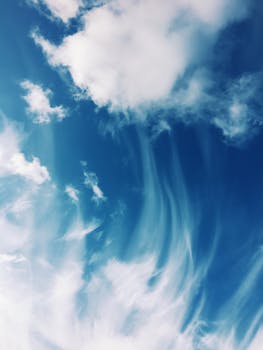 Serene cloud formations against a bright blue sky, capturing the beauty of daytime cloudscape.