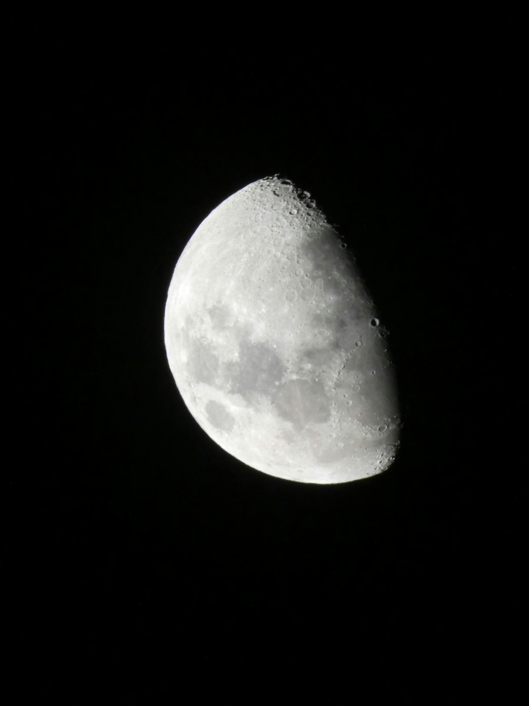 A clear image of the waxing gibbous moon set against a black sky, capturing lunar details.