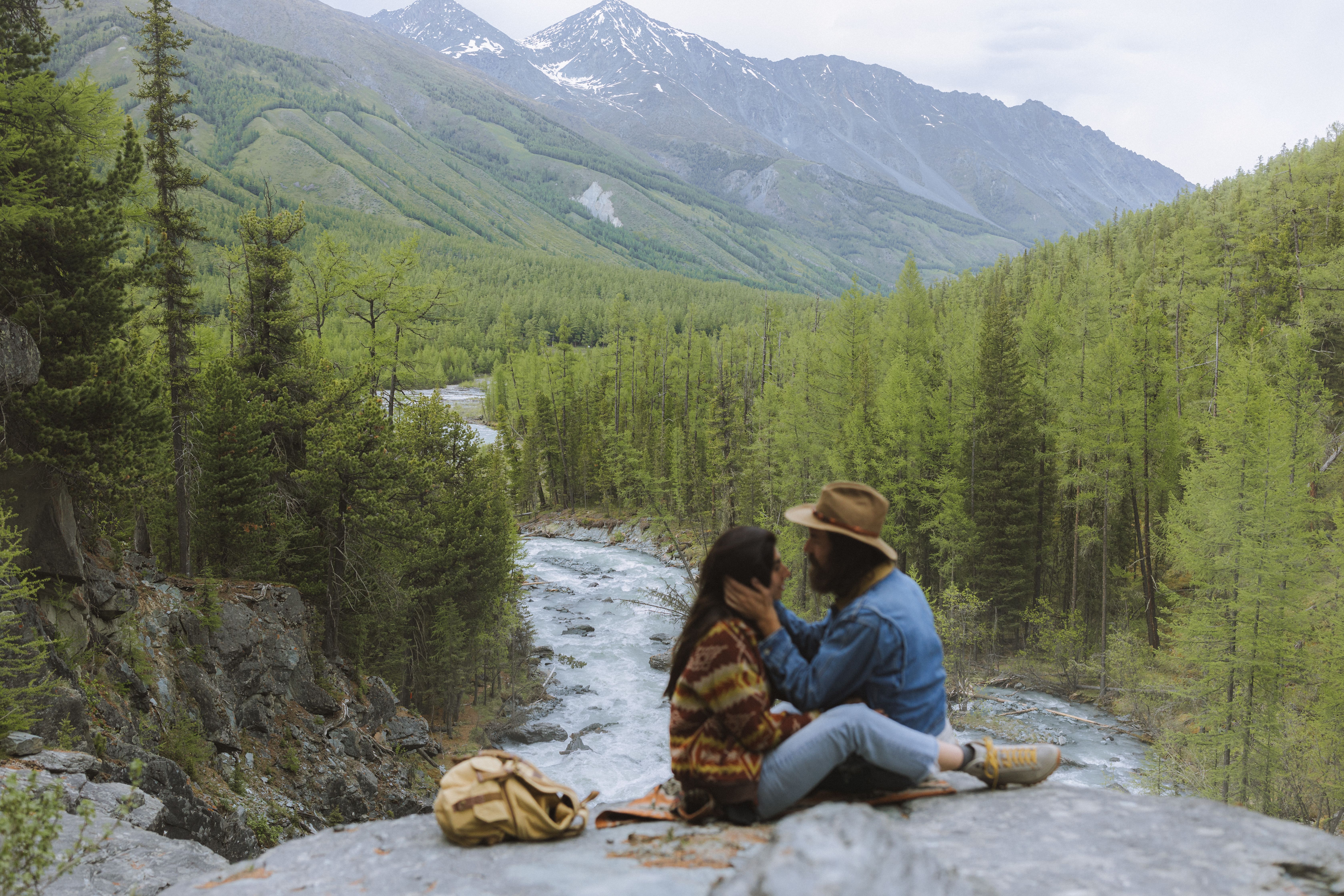 Man and Woman Sitting on a Rocky Cliff · Free Stock Photo