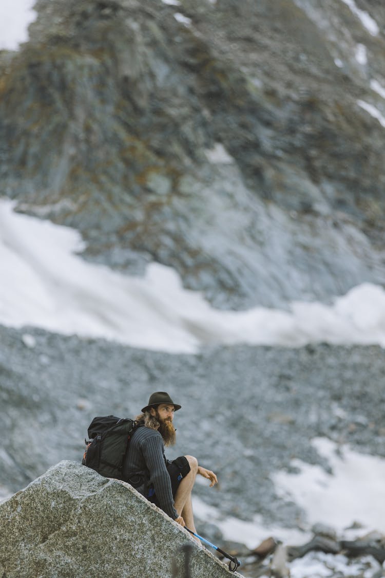 Man Sitting On A Big Rock On Mountainside