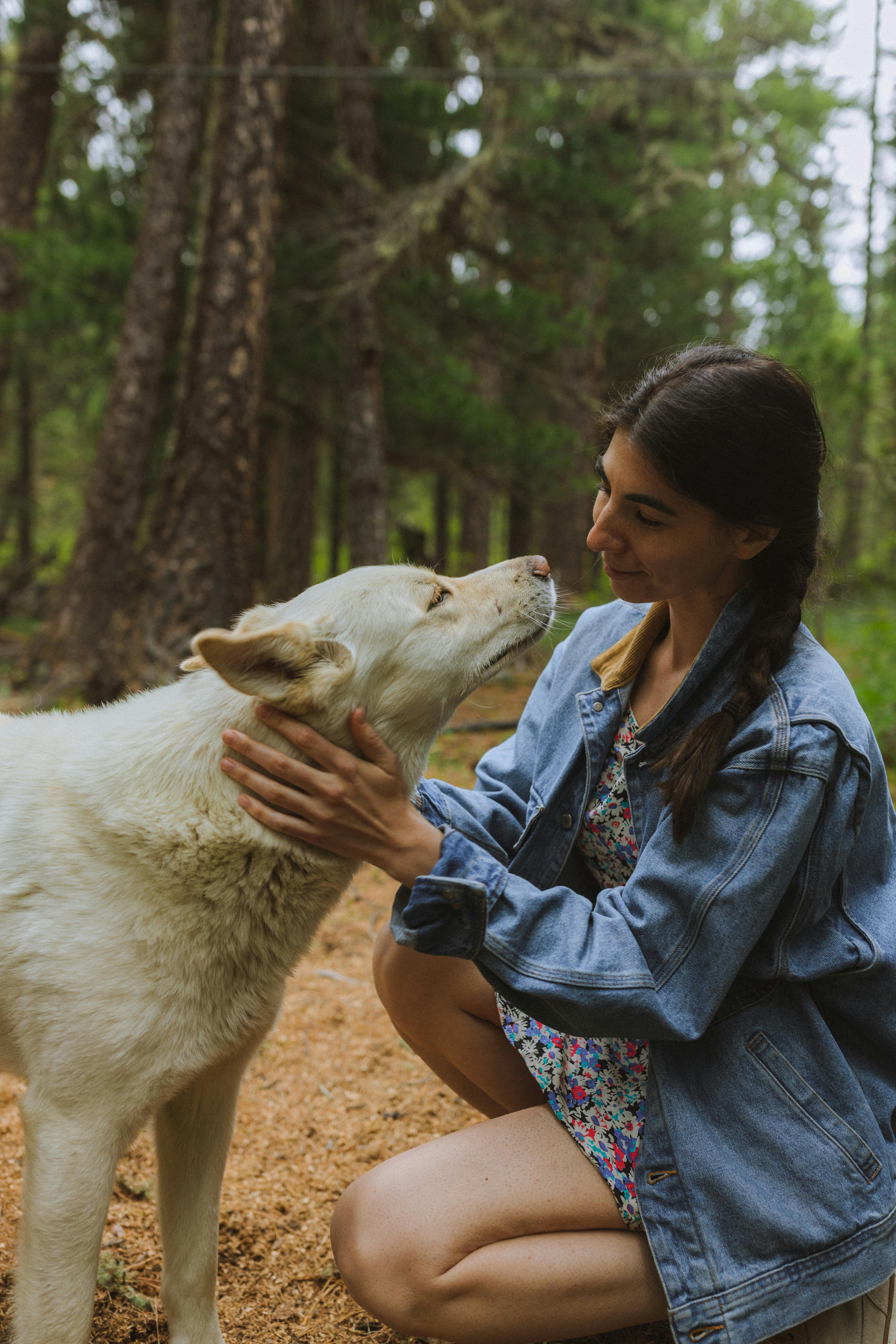 woman in denim jacket holding a dog